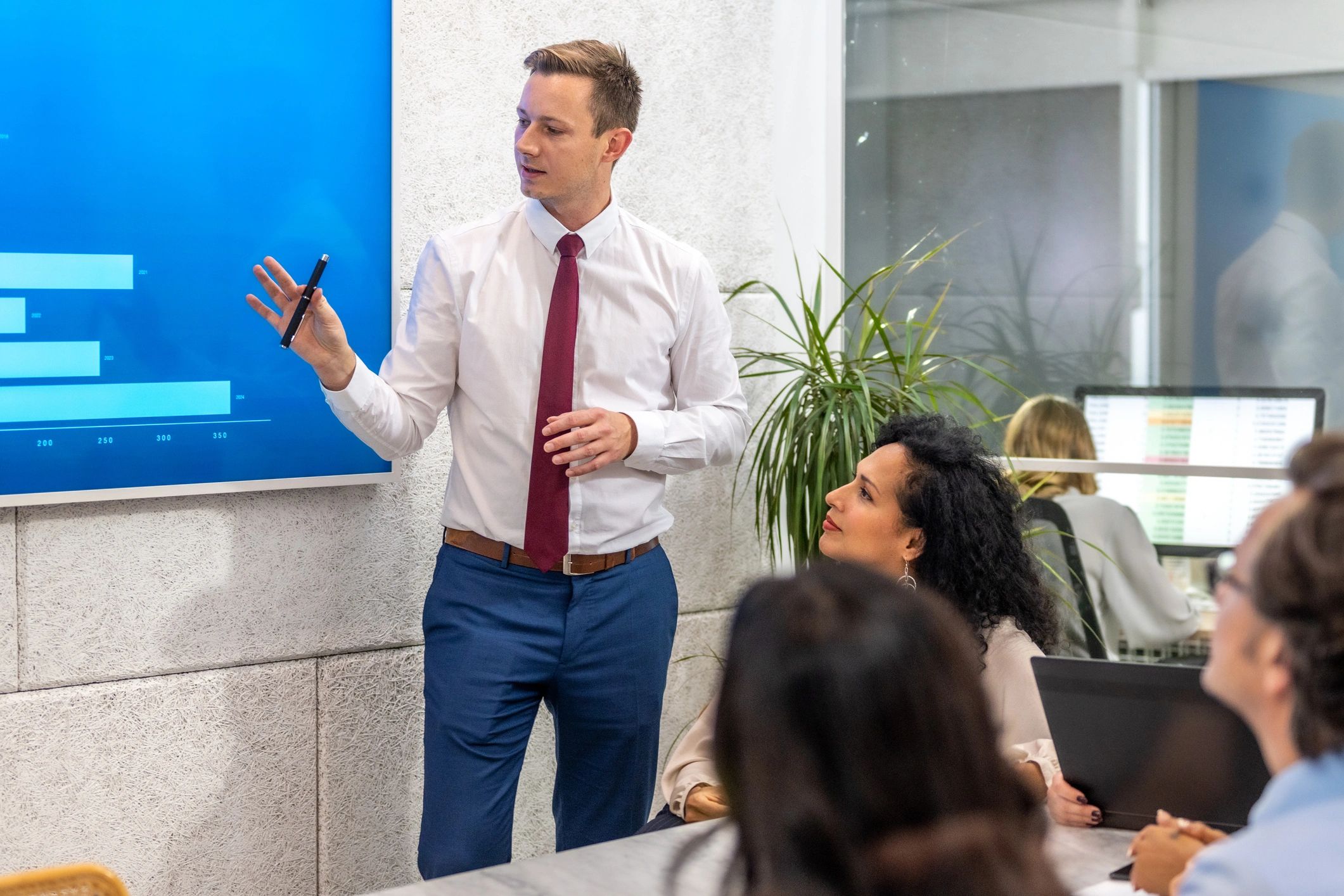 Presenter reviewing financial analytics with colleagues in a conference room