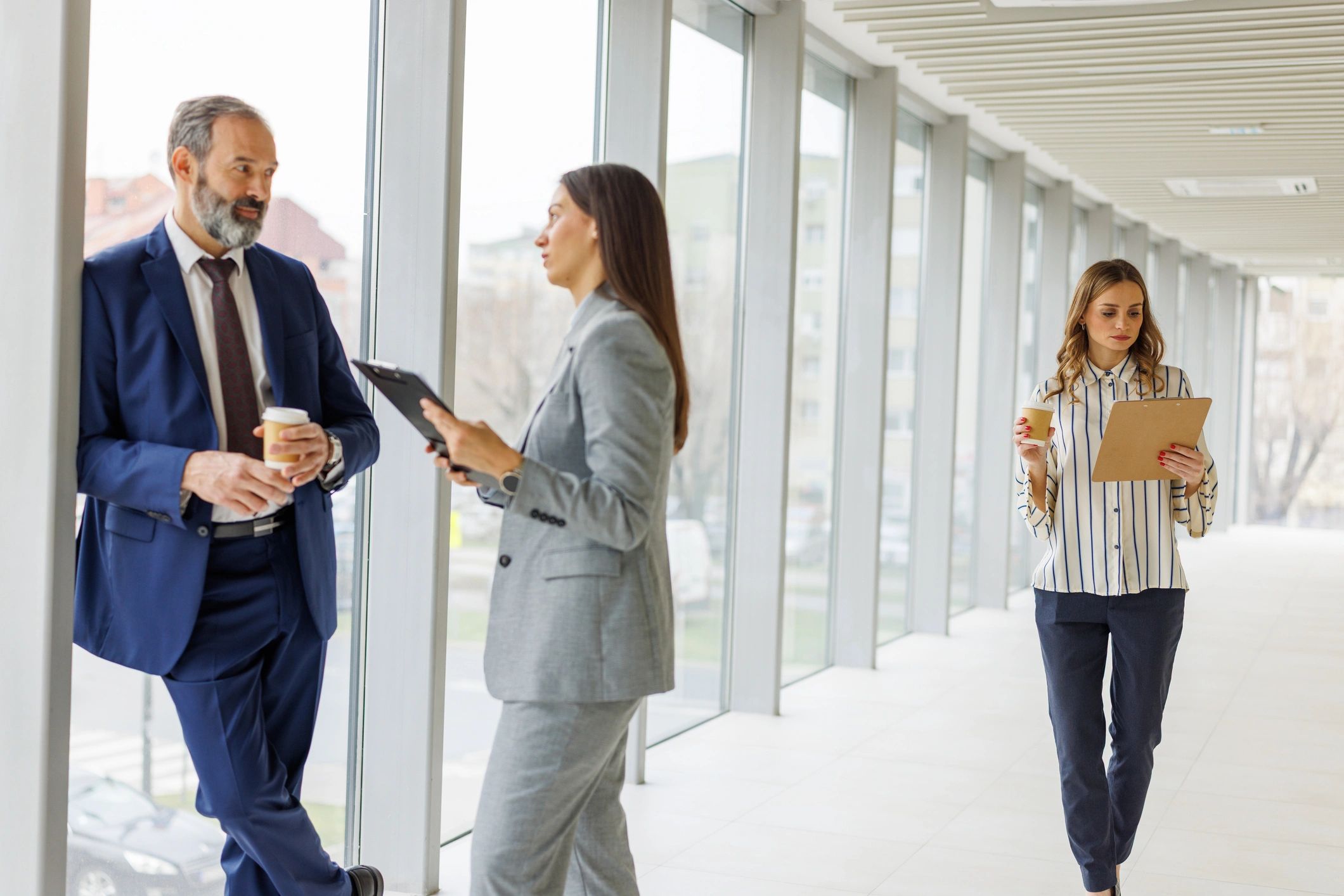 Business people discussing ideas in modern office hallway